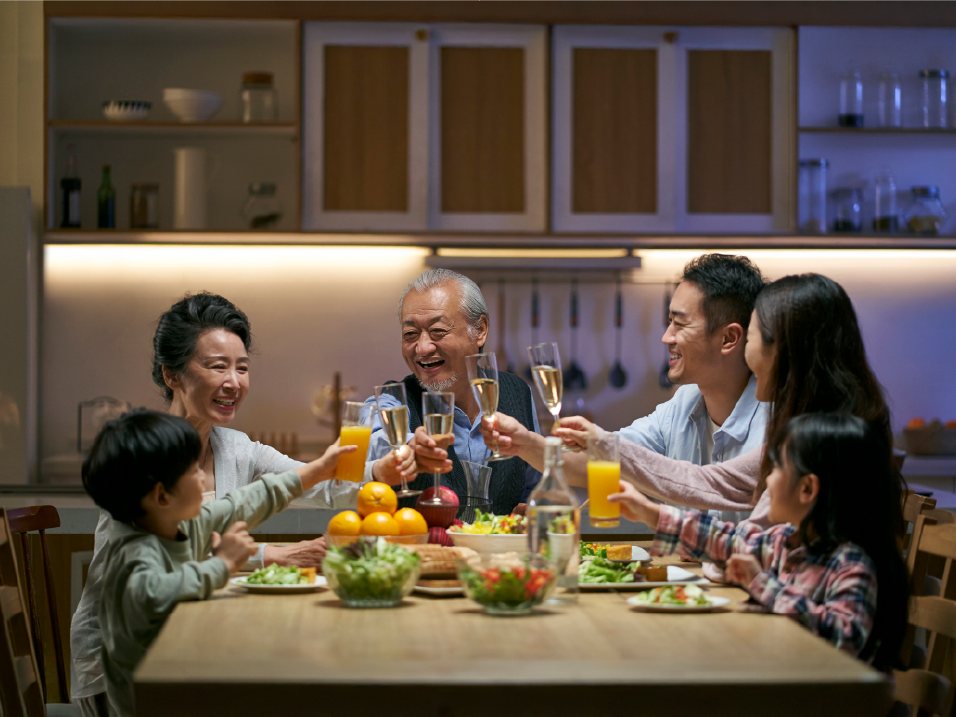 Ba thế hệ trong gia đình quây quần bên bàn ăn dưới ánh sáng ấm
