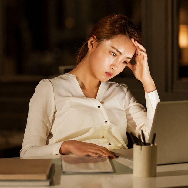 Người phụ nữ mệt mỏi trước màn hình máy tính buổi tối